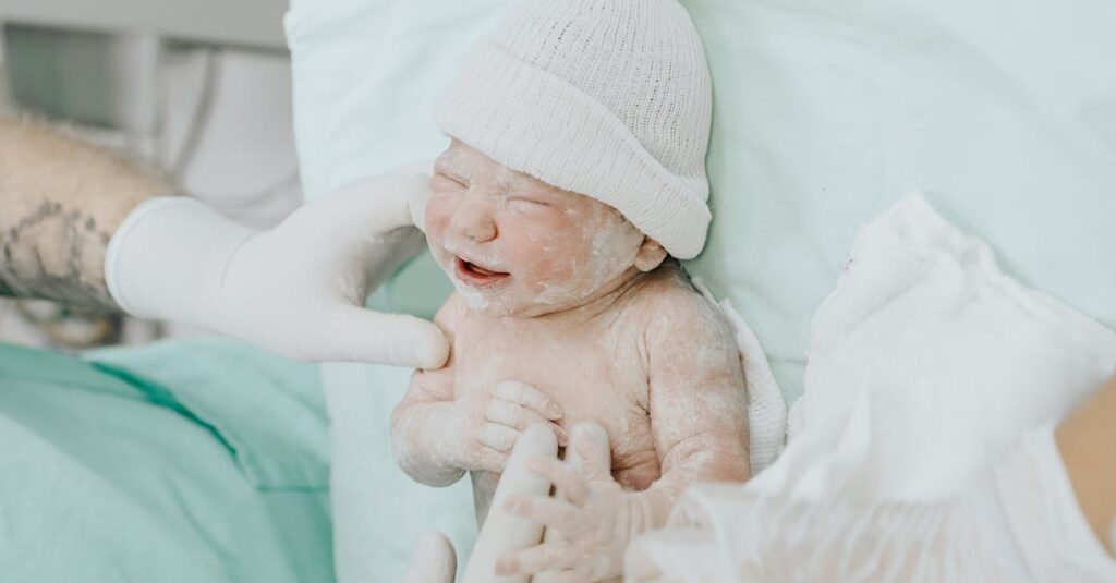 A newborn baby just delivered, attended by medical staff wearing gloves in a hospital setting.