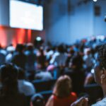 Vibrant crowd at a conference with a focus on an attentive participant.