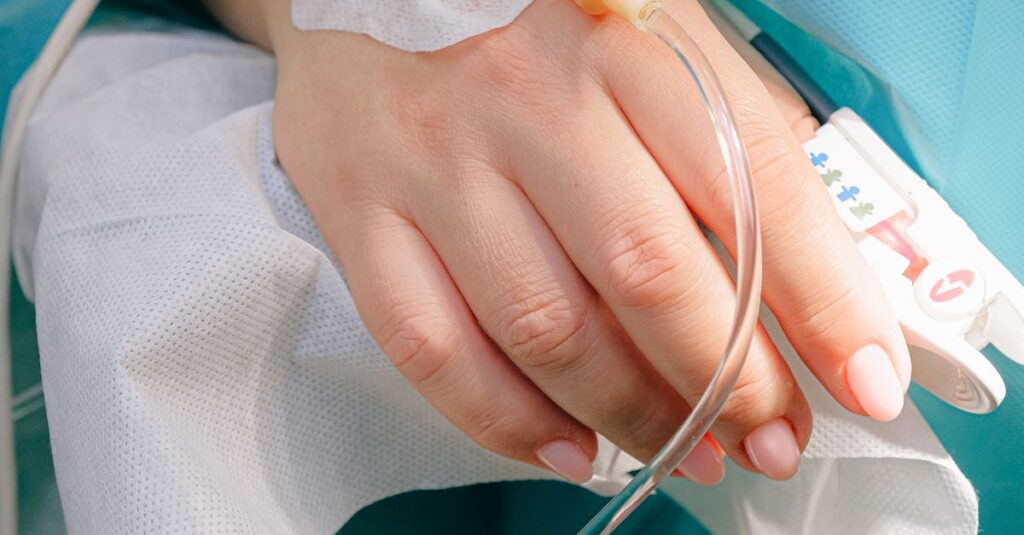 Close-up of a patient's hand receiving intravenous therapy in a hospital setting.