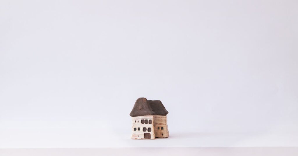 Minimalistic photo of a handmade clay miniature house placed on a clean white background.