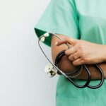Close-up of a healthcare worker holding a stethoscope, showcasing medical professionalism.