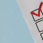 A simple white paper checklist with one red checkmark, ideal for concepts like completion or approval.