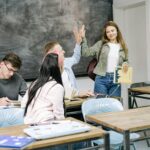 Group of students interacting and studying in a college classroom setting.