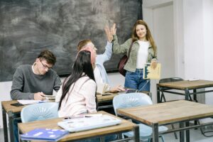 Group of students interacting and studying in a college classroom setting.