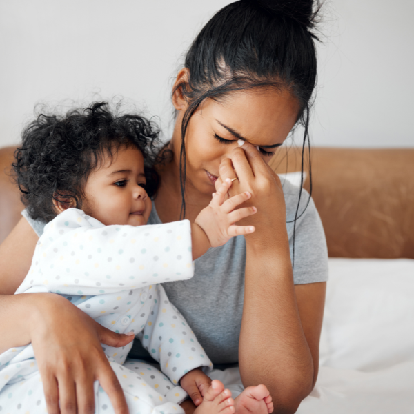 Stressed mother holding infant